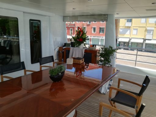 Tavolo da pranzo elegante con piante e fiori in un ambiente luminoso e moderno.