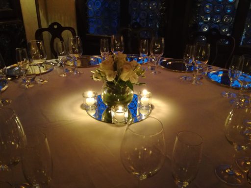 Centrotavola fiorito con candele su un tavolo elegantemente apparecchiato.