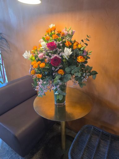 Vaso di fiori colorati su un tavolo rotondo in un ambiente accogliente.